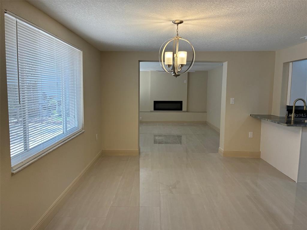 13916 Muriel Avenue Hudson, FL 34667 - Photo 6 of 9 an empty room with wooden floor and chandelier