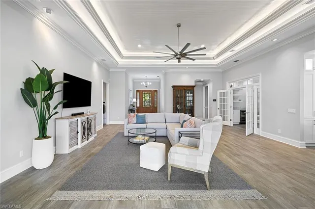 a living room with furniture a chandelier and a flat screen tv