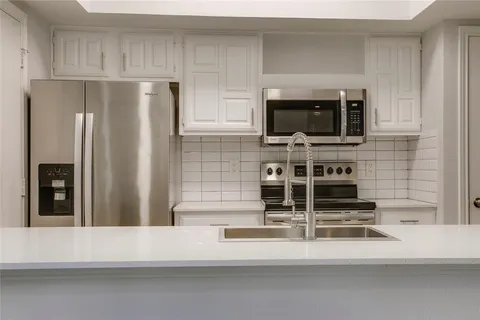 a kitchen with stainless steel appliances a refrigerator and a stove top oven