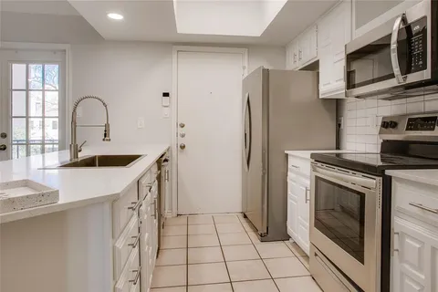 a kitchen with stainless steel appliances granite countertop a refrigerator sink and stove