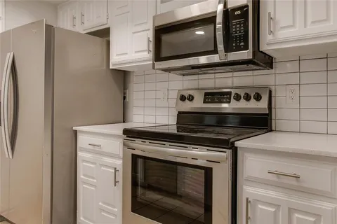 a kitchen with stainless steel appliances white cabinets and a stove