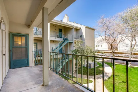 a view of a house with a floor to ceiling window and wooden fence