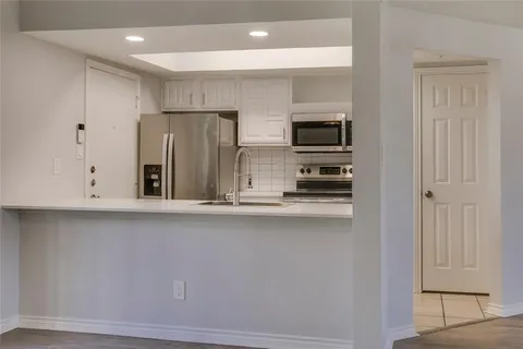 a kitchen with stainless steel appliances a refrigerator and microwave