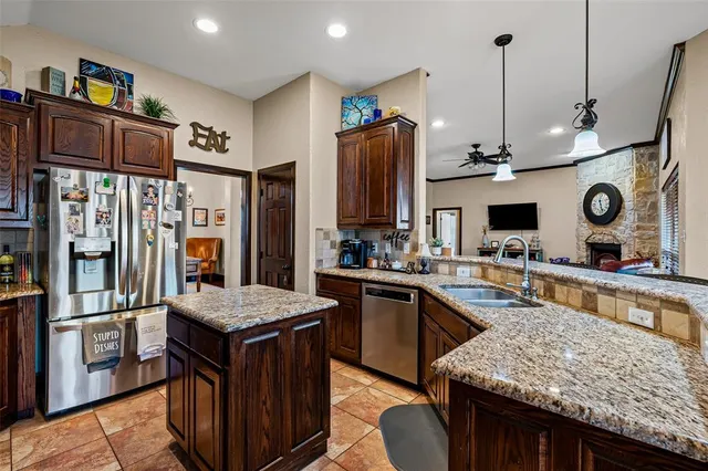 a kitchen with stainless steel appliances granite countertop sink stove top oven and refrigerator