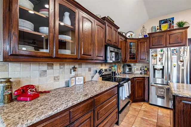 a kitchen with stainless steel appliances granite countertop a stove and cabinets