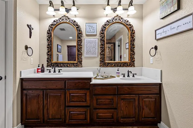 a bathroom with double vanity sinks and a mirror