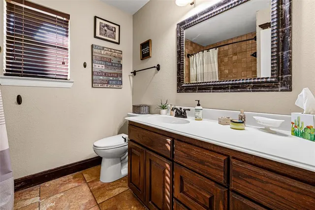 a bathroom with a granite countertop sink mirror and a toilet