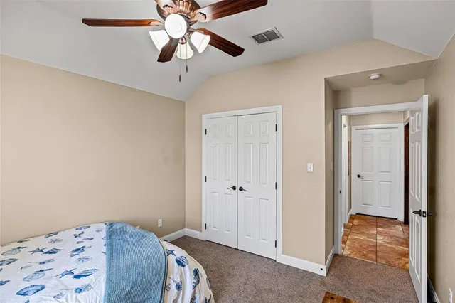 a bedroom with a bed and a chandelier fan