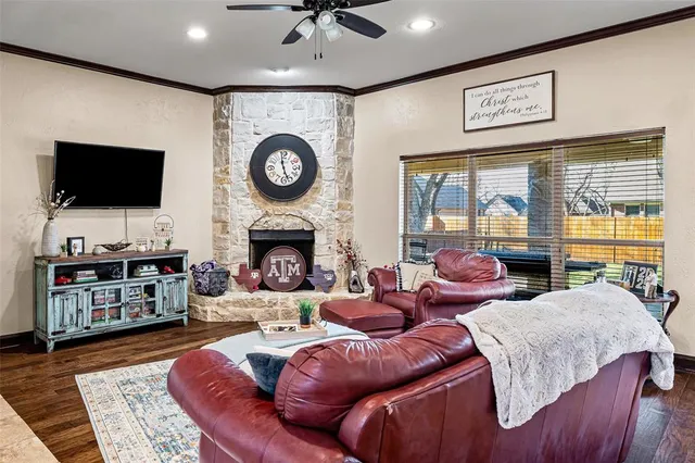 a living room with furniture a flat screen tv and a fireplace
