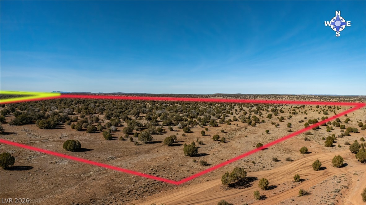 0 X-One Ranch Road Seligman, AZ 86337 - Photo 1 of 9 A vast, undeveloped lot awaits your vision under an expansive blue sky.