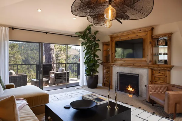a living room with furniture a fireplace and a chandelier