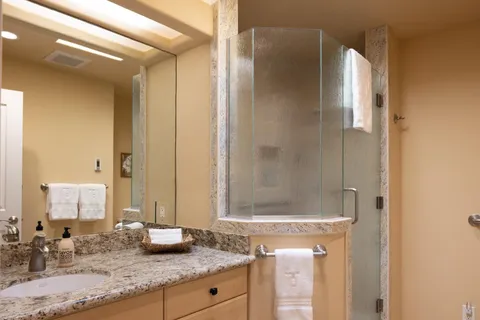 a bathroom with a granite countertop sink and a mirror