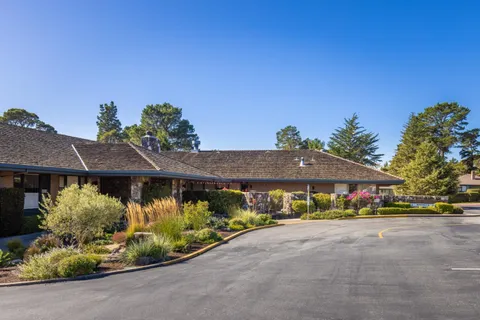 a front view of a house with a yard and outdoor seating