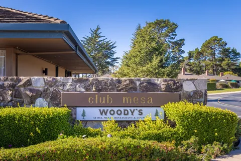 a view of a sign board with flower plants