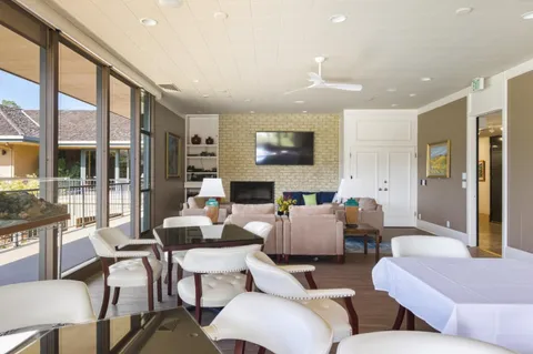 a living room with fireplace furniture and a large window