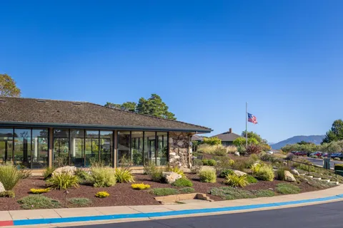 a front view of a house with swimming pool and furniture