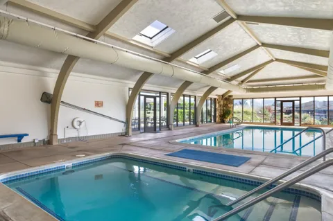 a very nice looking room with many windows and furniture