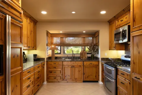 a kitchen with counter top space appliances and windows