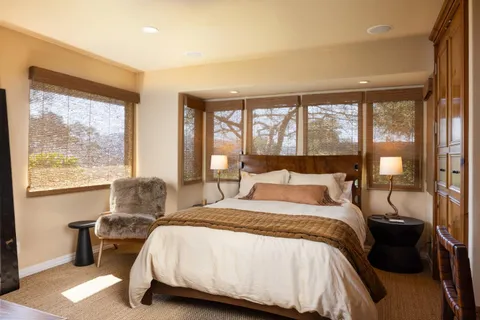 a bedroom with a bed and a large window