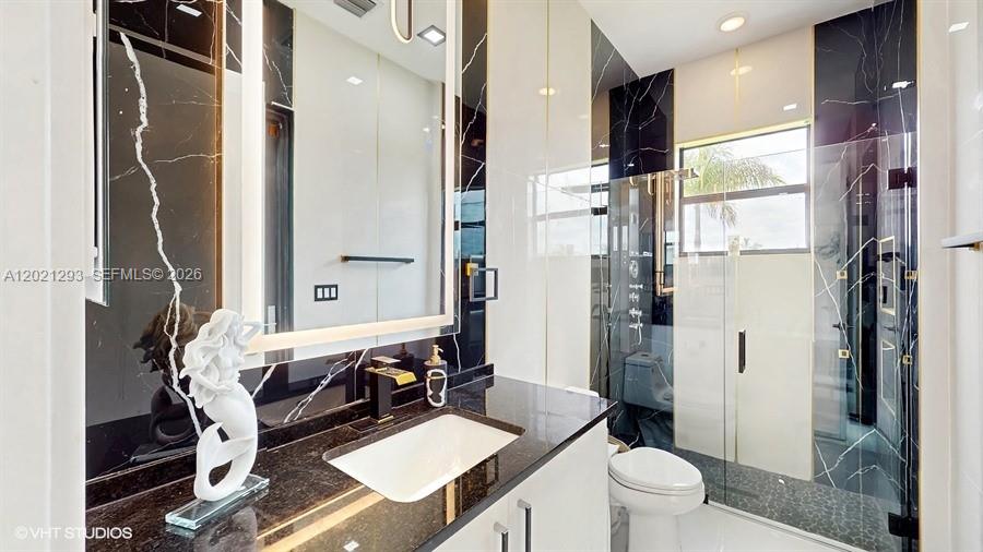 8350 Royal County Down Road Boca Raton, FL 33434 - Photo 18 of 52 a bathroom with a double vanity sink toilet and shower