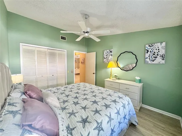 a bedroom with a large bed and a chandelier