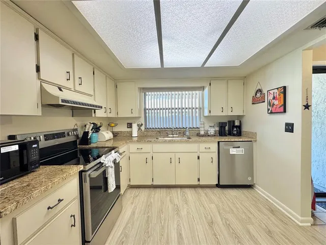 a kitchen with stainless steel appliances granite countertop a stove sink and cabinets