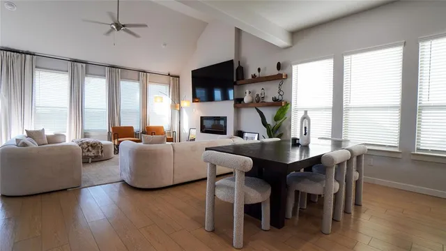 a living room with furniture a large window and wooden floor