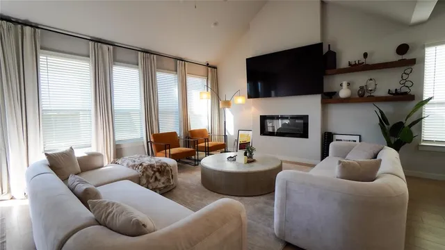 a living room with furniture a flat screen tv and a large window