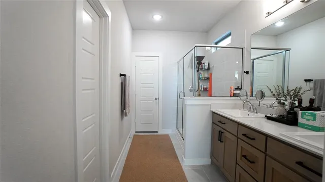 a bathroom with a double vanity sink mirror and shower
