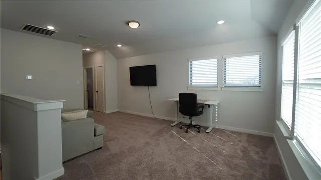 a view of a livingroom with workspace and a window