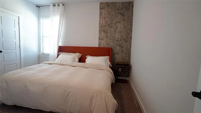 a large bed sitting in a bedroom next to a window