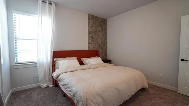 a large bed sitting in a bedroom next to a window