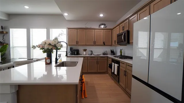 a kitchen with kitchen island granite countertop a sink appliances cabinets and a counter top space
