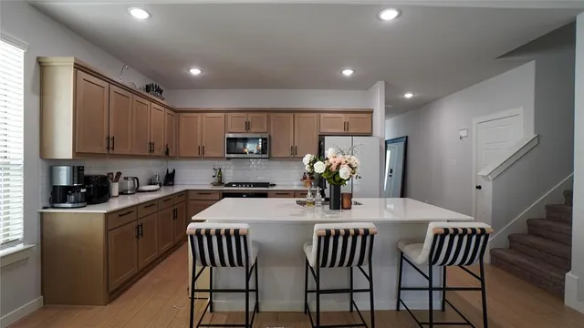 a kitchen with a dining table chairs and refrigerator