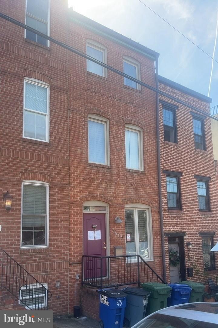 3409 Dillon Street Baltimore, MD 21224 - Photo 1 of 18 a front view of a building with garden