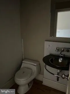 a bathroom with a toilet a sink and mirror