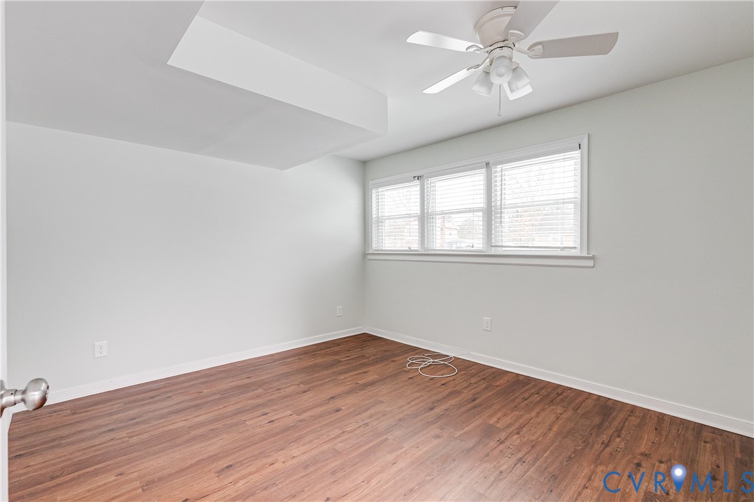 10907 Baxter Road Glen Allen, VA 23060 - Photo 33 of 42 an empty room with wooden floor chandelier fan and windows