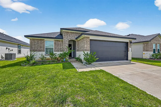 a front view of a house with a garden and plants