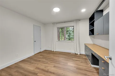 an empty room with windows and fireplace