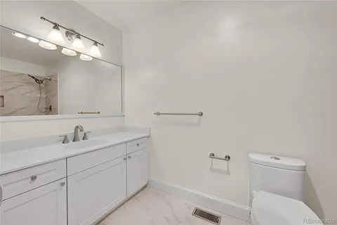 a bathroom with a sink vanity and a toilet