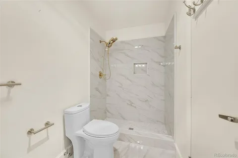 a bathroom with a shower a toilet and a sink