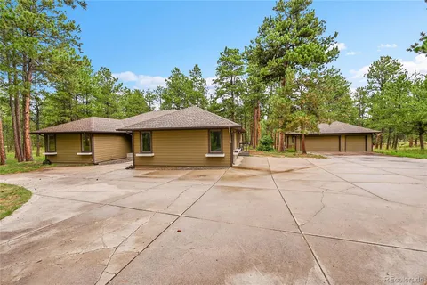 a view of a house with a yard and large tree