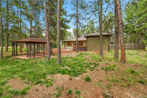 a view of a patio with table and chairs under an umbrella
