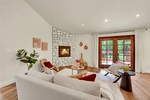 a living room with furniture floor to ceiling window and a flat screen tv