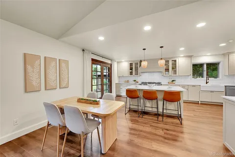 a living room with stainless steel appliances kitchen island granite countertop furniture and a wooden floor