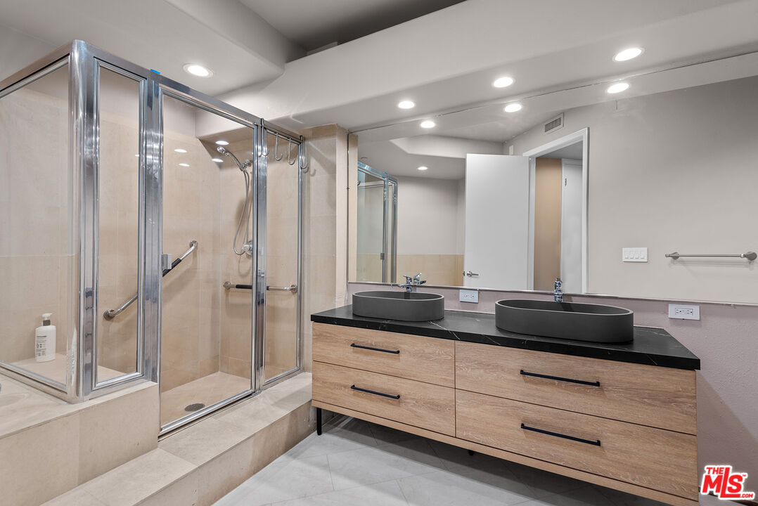 1875 South Beverly Glen Boulevard, Unit 106 Los Angeles, CA 90025 - Photo 18 of 30 a bathroom with a double vanity sink and mirror with shower