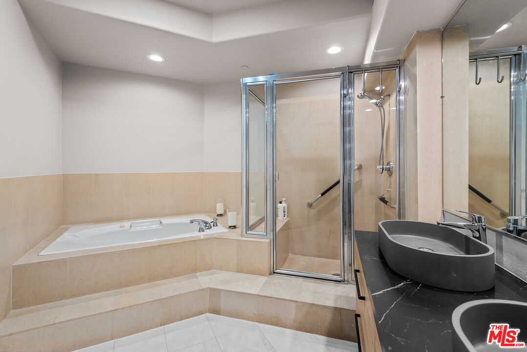 1875 South Beverly Glen Boulevard, Unit 106 Los Angeles, CA 90025 - Photo 19 of 30 a spacious bathroom with a tub and a large mirror