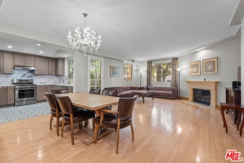a view of a dining room with furniture a fireplace and wooden floor