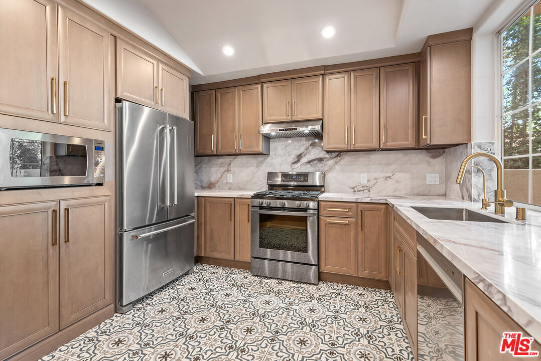 1875 South Beverly Glen Boulevard, Unit 106 Los Angeles, CA 90025 - Photo 10 of 30 a kitchen with stainless steel appliances granite countertop a refrigerator sink and stove