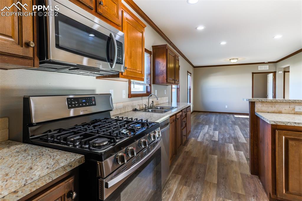 703 Buffalo Run Road Calhan, CO 80808 - Photo 11 of 25 a kitchen with stainless steel appliances granite countertop a stove and a microwave
